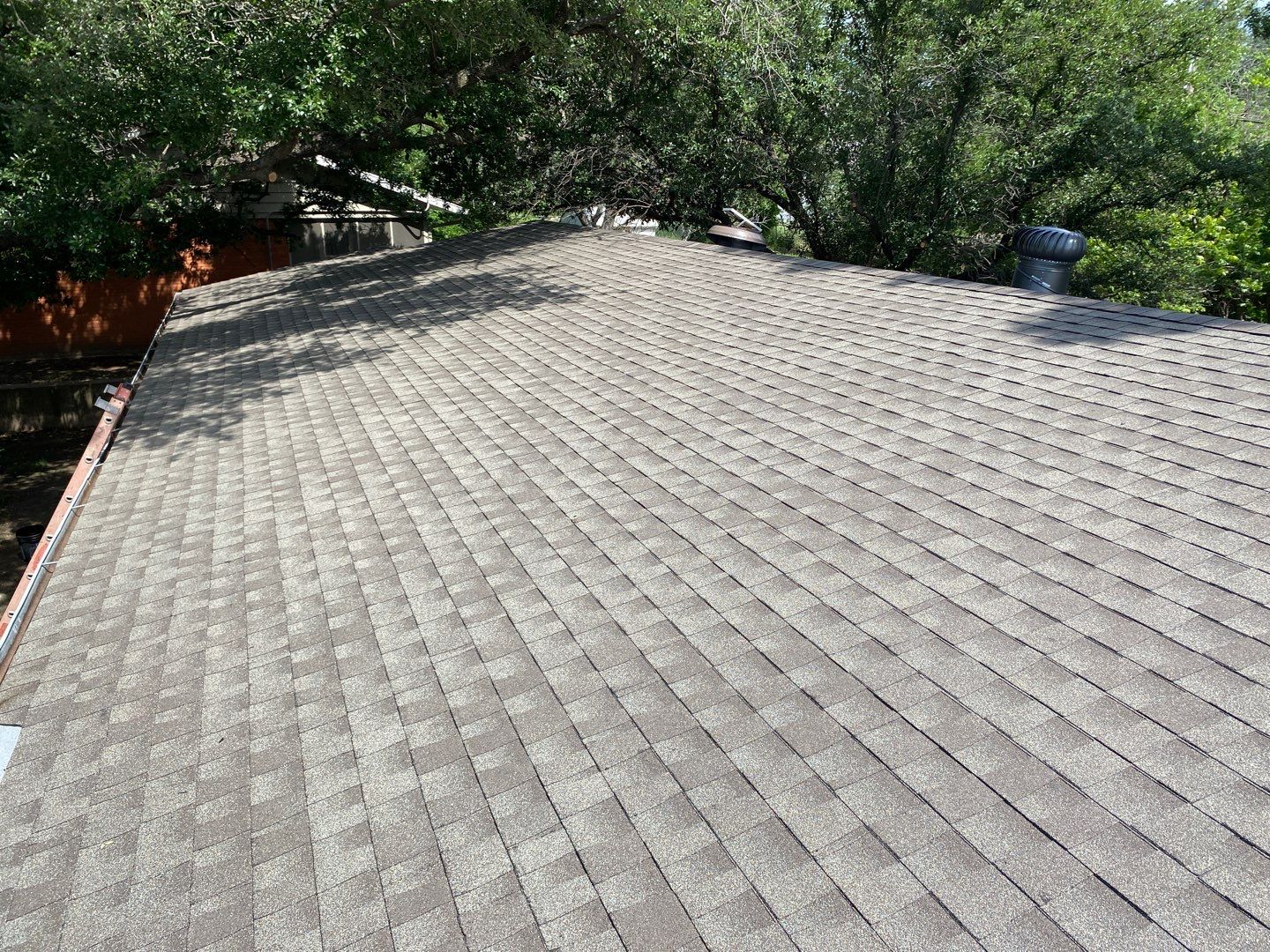 Close-up view of brand new asphalt shingles after a full roof replacement.