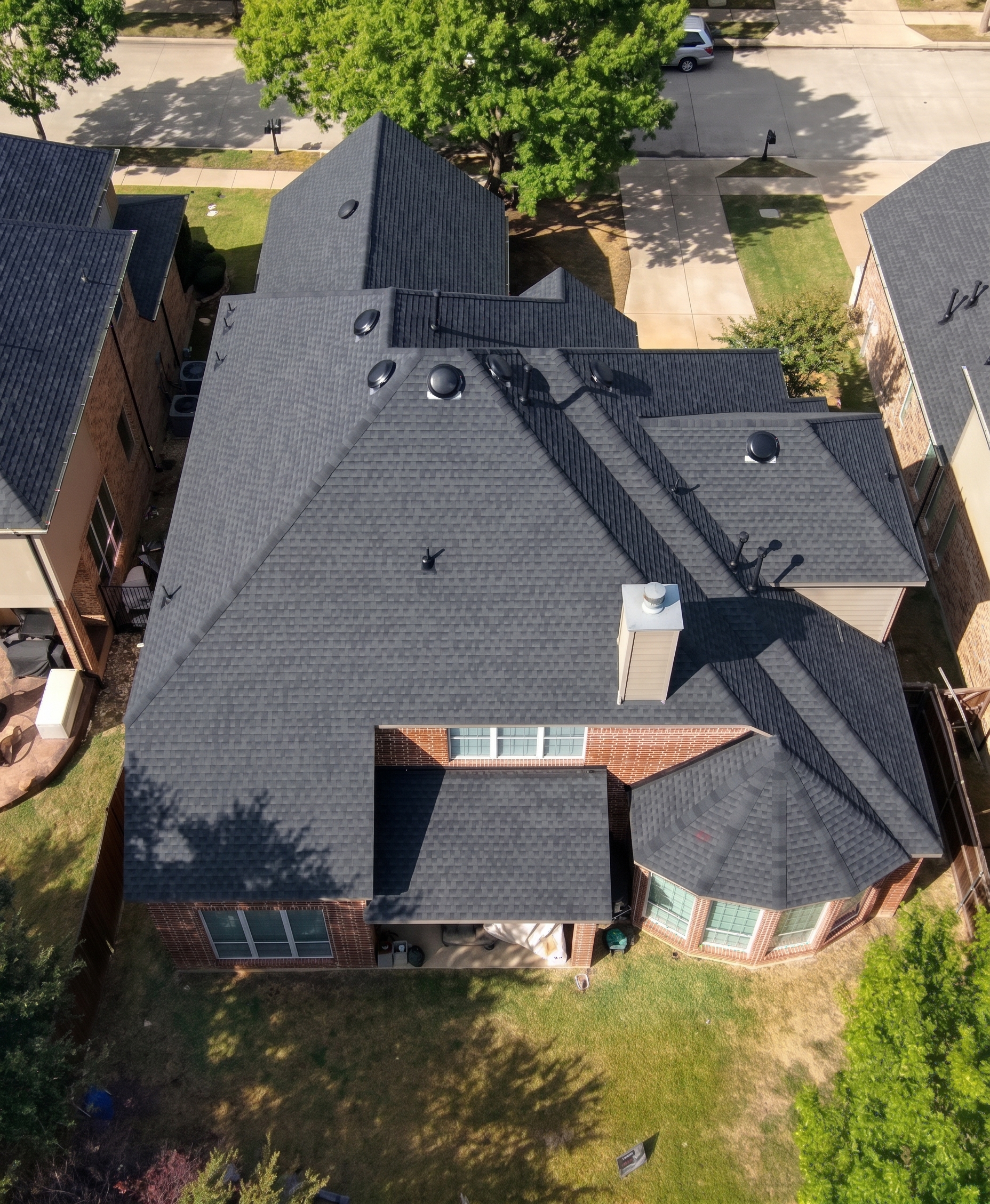 Professional photo of the house after roof replacement with our company yard sign in the front.